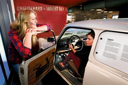 women sitting in and standing next to a Trabi