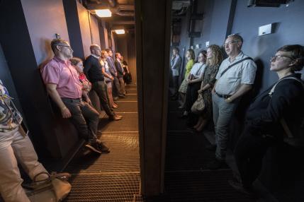 Menschen schauen sich in zwei Räumen etwas an