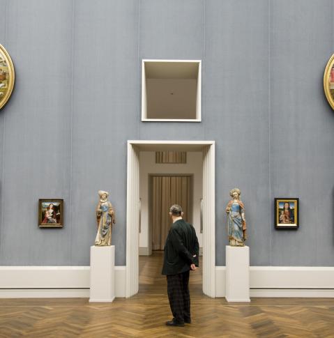 un homme admire les tableaux de la galerie de peinture